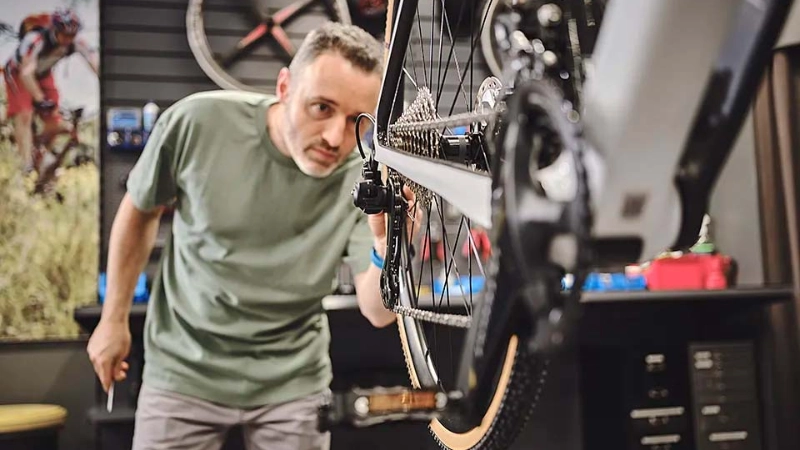 Ein Fachhändler blickt auf ein Hinterrad