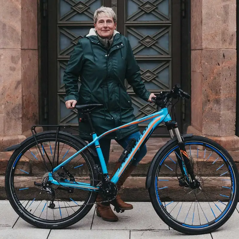 Yvonne Matthes von der Lecos GmbH steht mit ihrem Fahrrad vor der Eingangstür
